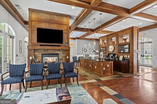 living room with dark wood-type flooring, a fireplace, french doors, and beamed ceiling