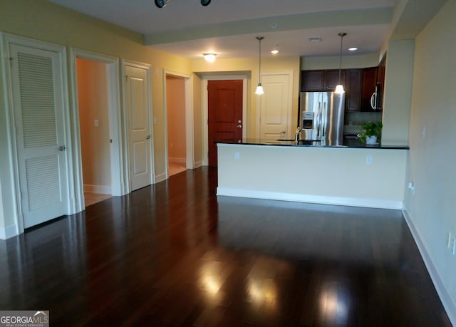 kitchen featuring appliances with stainless steel finishes, dark brown cabinets, dark wood-type flooring, and decorative light fixtures