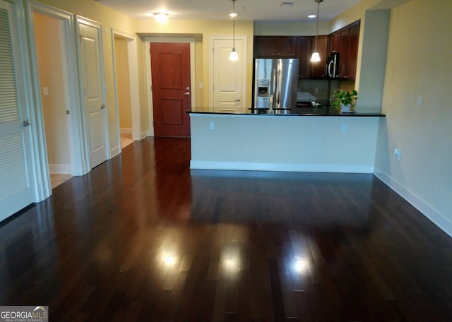 kitchen featuring pendant lighting, dark brown cabinets, dark wood-type flooring, and appliances with stainless steel finishes