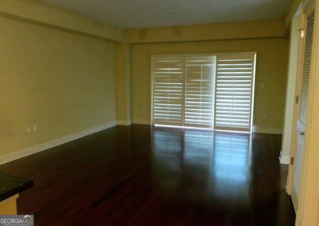 spare room with dark wood-type flooring