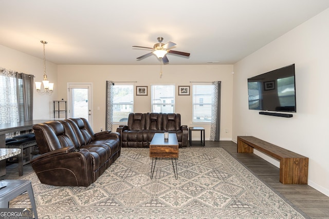 living room with ceiling fan with notable chandelier and wood-type flooring