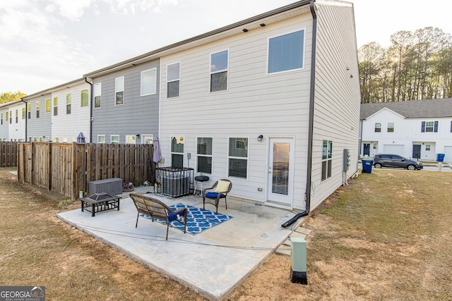 back of property featuring a yard, a fire pit, and a patio