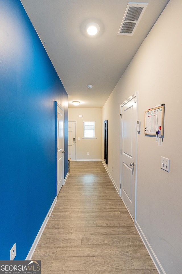 hallway with light hardwood / wood-style floors