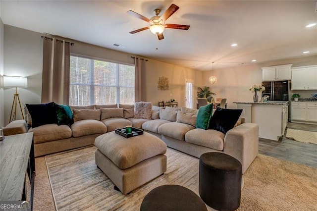 living room featuring light hardwood / wood-style flooring and ceiling fan