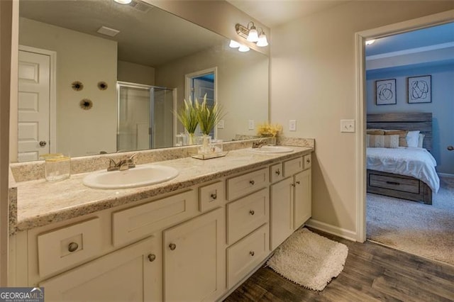 bathroom with hardwood / wood-style flooring, vanity, and walk in shower