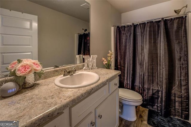 bathroom with vanity, wood-type flooring, and toilet