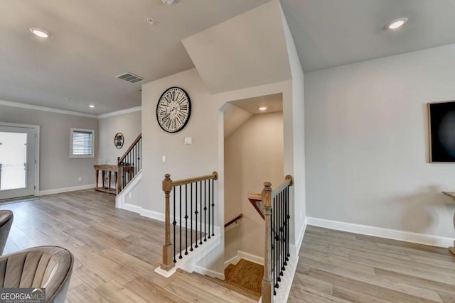 stairs with hardwood / wood-style flooring and ornamental molding