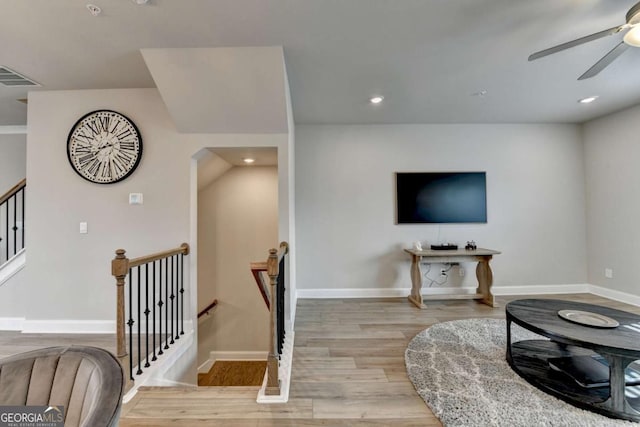 living room with light hardwood / wood-style flooring and ceiling fan