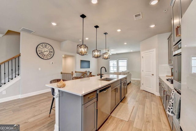 kitchen featuring pendant lighting, an island with sink, sink, a breakfast bar area, and stainless steel appliances