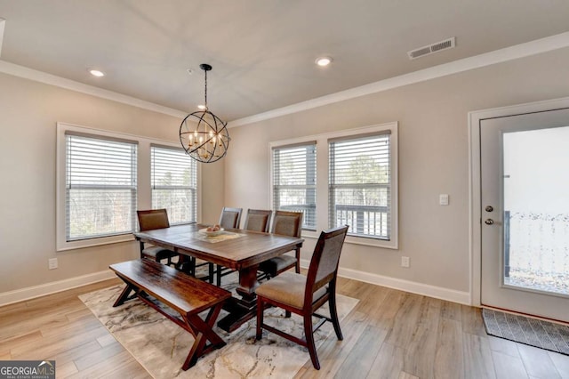 dining room featuring a notable chandelier, light hardwood / wood-style flooring, and ornamental molding