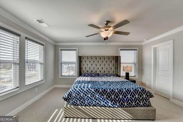 carpeted bedroom featuring crown molding and ceiling fan