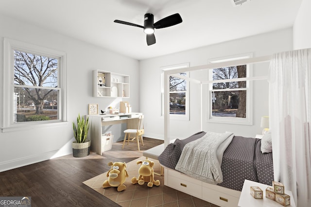 bedroom with ceiling fan, dark wood-style flooring, visible vents, and baseboards