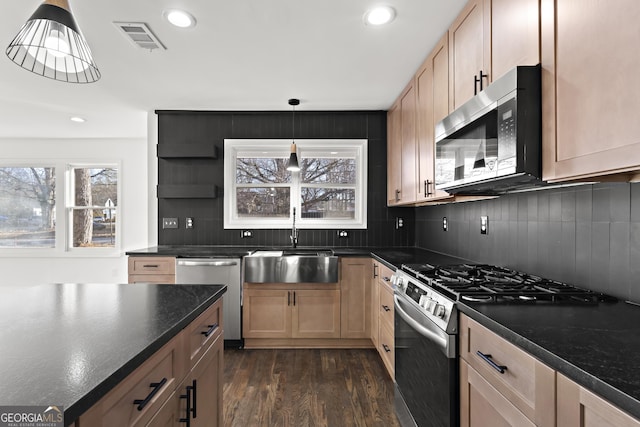 kitchen featuring appliances with stainless steel finishes, dark countertops, visible vents, and open shelves