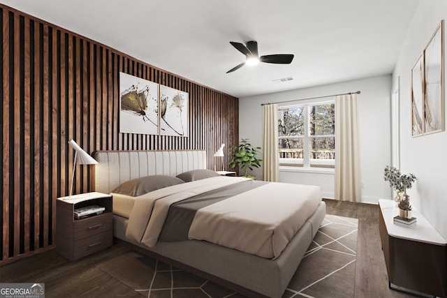 bedroom with ceiling fan, dark wood-style flooring, and visible vents