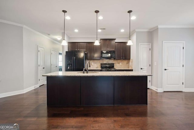 kitchen with sink, black appliances, an island with sink, light stone countertops, and decorative light fixtures