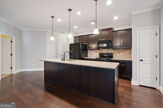 kitchen featuring dark hardwood / wood-style floors, an island with sink, hanging light fixtures, dark brown cabinetry, and black appliances