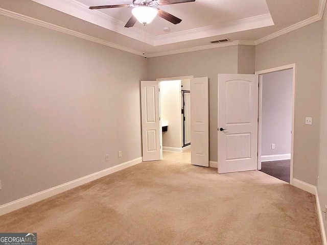 carpeted spare room featuring a raised ceiling, crown molding, and ceiling fan