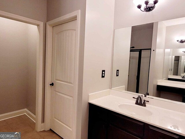 bathroom featuring a shower with door and vanity