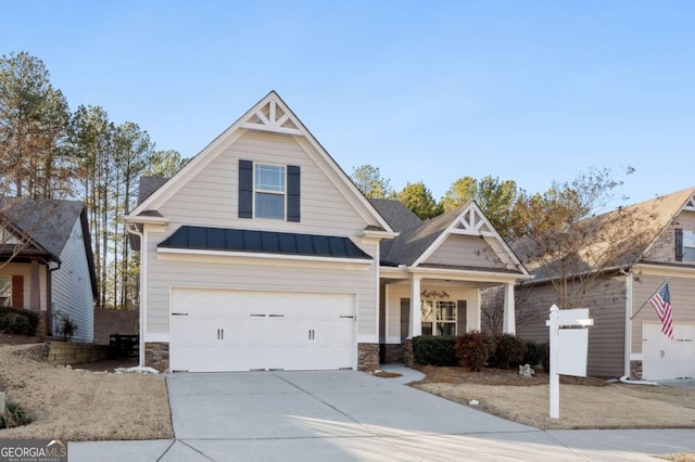 view of front facade with stone siding, driveway, metal roof, and a standing seam roof