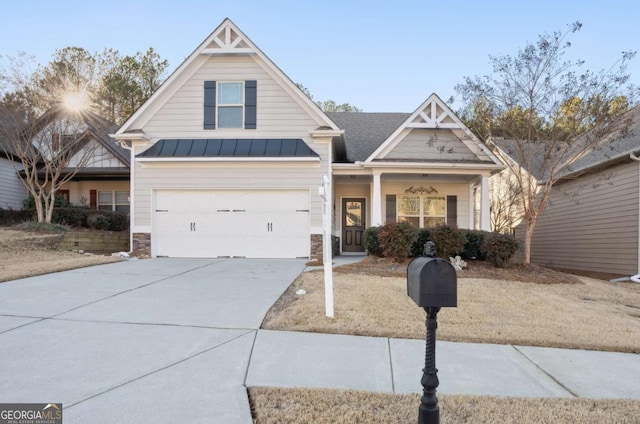 view of front of house featuring a standing seam roof, stone siding, driveway, and metal roof