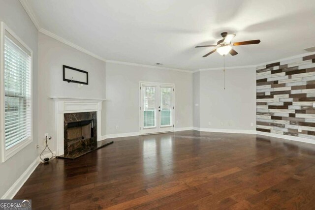 unfurnished living room featuring ornamental molding, dark hardwood / wood-style floors, ceiling fan, and a high end fireplace