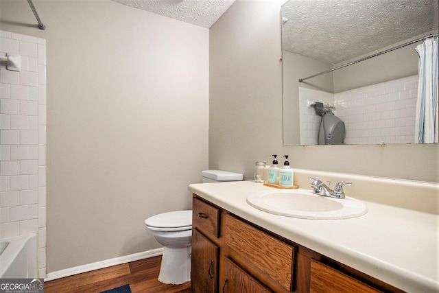 full bathroom featuring shower / tub combo with curtain, hardwood / wood-style flooring, vanity, toilet, and a textured ceiling