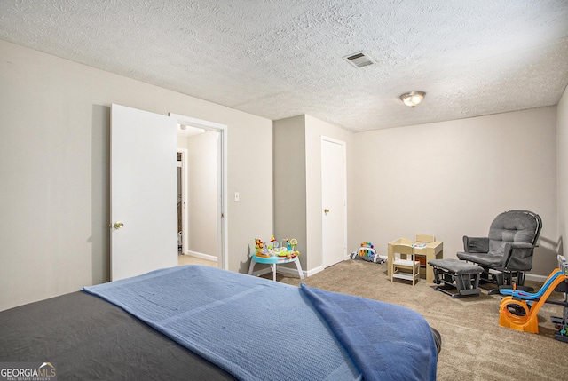 bedroom with carpet and a textured ceiling