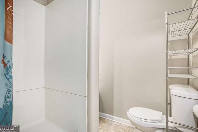 bathroom featuring a shower with curtain and toilet