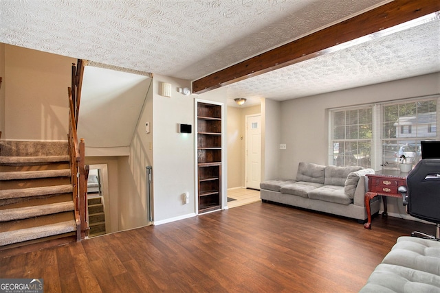 living room featuring beam ceiling, a textured ceiling, and dark hardwood / wood-style flooring