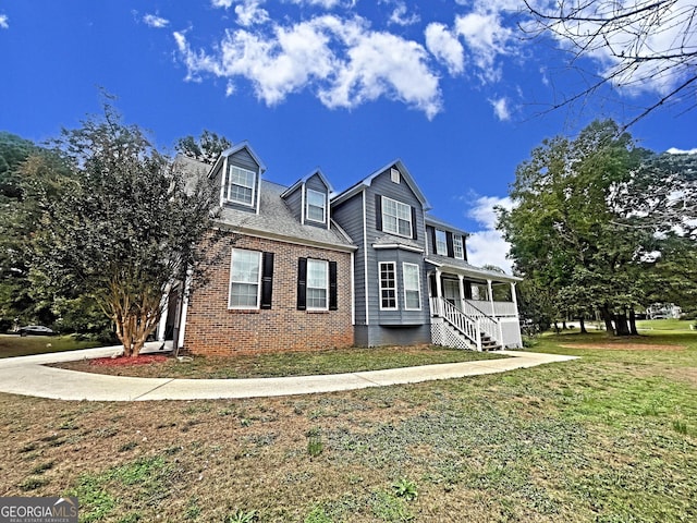 view of front of house with covered porch and a front lawn