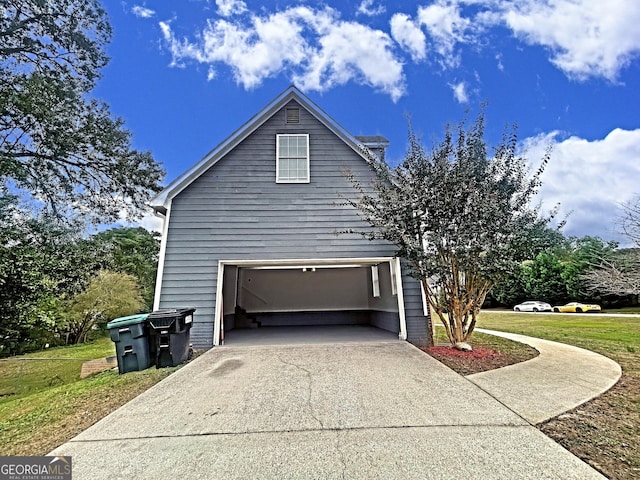 view of side of property with driveway and a garage