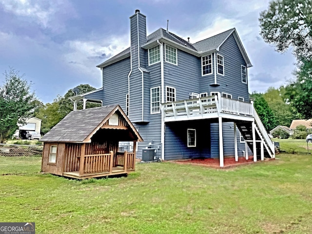 back of house featuring cooling unit, a wooden deck, and a yard