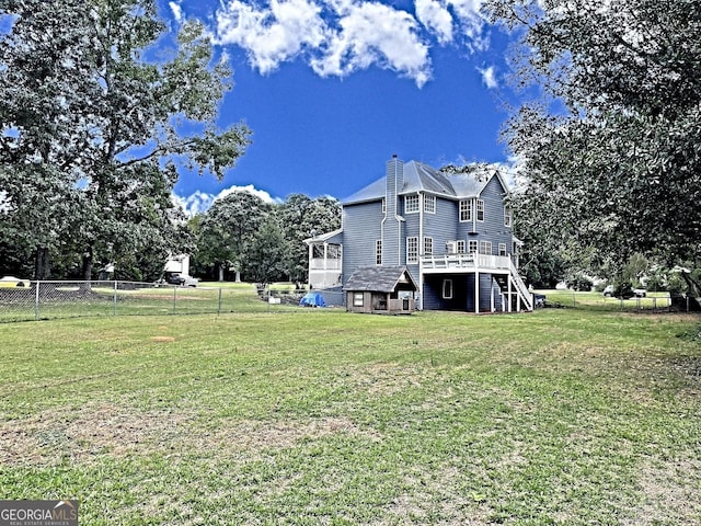 view of property exterior featuring a fenced backyard, stairway, a wooden deck, and a yard