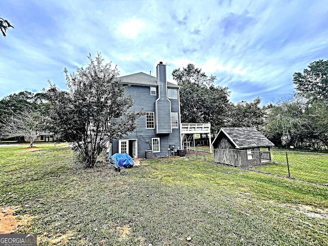 view of side of property with a chimney, an outbuilding, and a yard