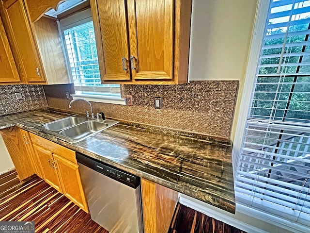 kitchen featuring a sink, dark countertops, brown cabinetry, and dishwasher