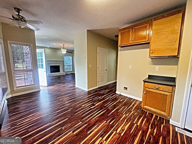 kitchen featuring dark wood-type flooring, a textured ceiling, and ceiling fan