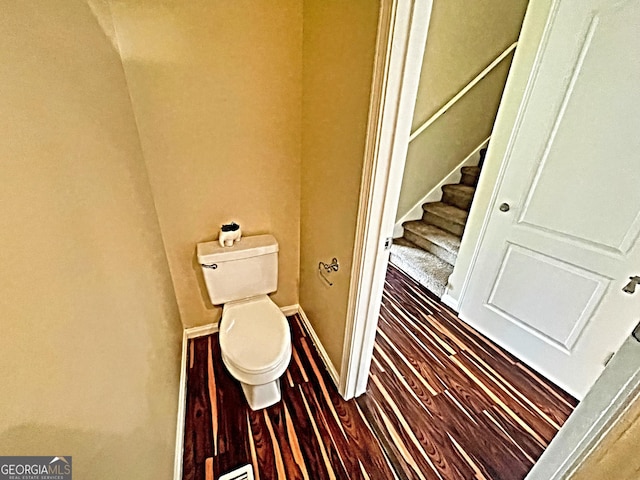 bathroom featuring baseboards, toilet, and wood finished floors