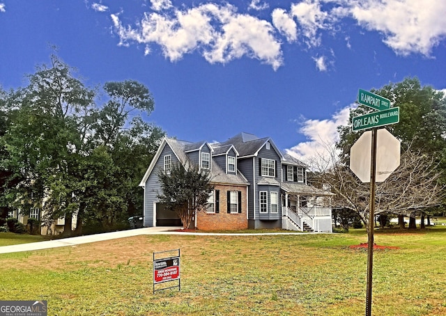 view of front of house featuring a garage, brick siding, concrete driveway, and a front yard