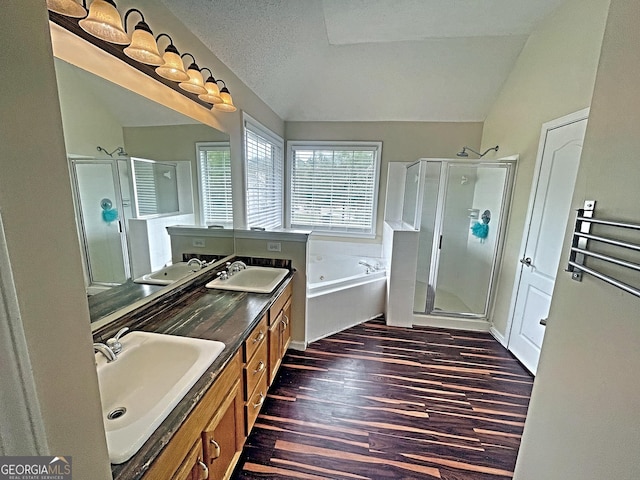 bathroom featuring lofted ceiling, vanity, hardwood / wood-style flooring, and shower with separate bathtub