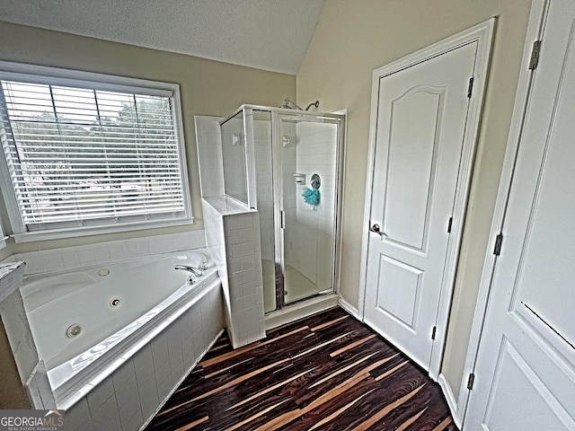 bathroom featuring wood-type flooring, shower with separate bathtub, and a textured ceiling