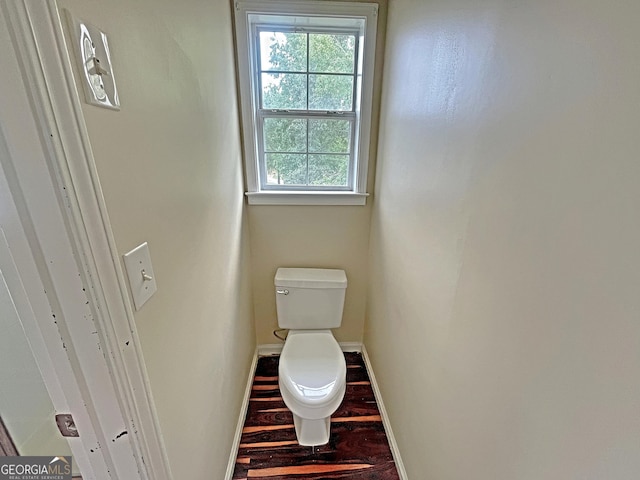 bathroom with toilet, baseboards, and wood finished floors