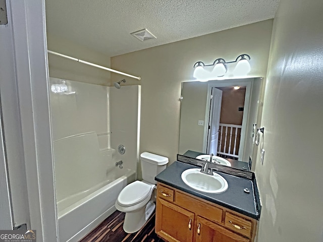 bathroom with shower / bathtub combination, visible vents, toilet, a textured ceiling, and vanity