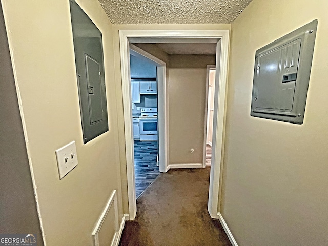 corridor with electric panel, baseboards, dark colored carpet, and a textured ceiling