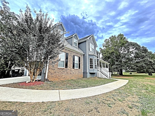 view of side of property with brick siding and a lawn