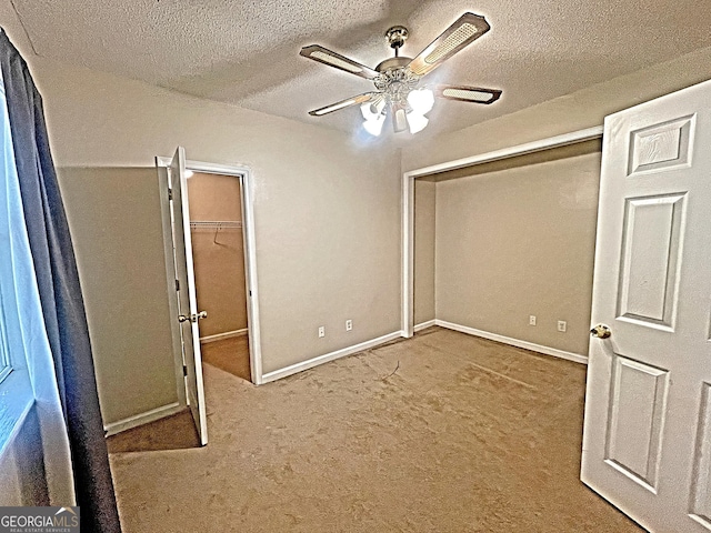 unfurnished bedroom with a textured ceiling, baseboards, and light colored carpet