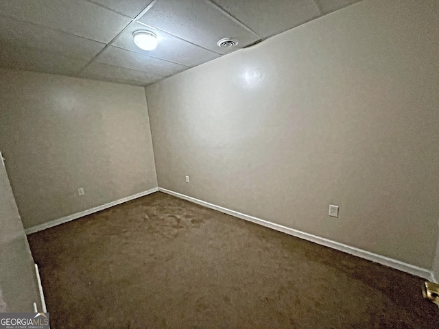 carpeted empty room featuring a drop ceiling, visible vents, and baseboards