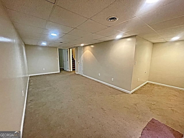 finished basement with visible vents, baseboards, a paneled ceiling, stairs, and carpet floors