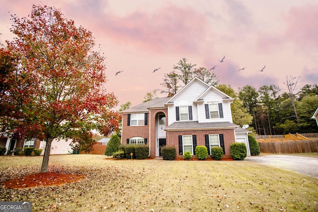 view of front of property with a garage and a lawn