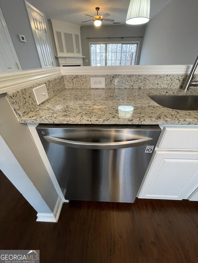 kitchen featuring sink, stainless steel dishwasher, dark hardwood / wood-style flooring, ceiling fan, and light stone countertops