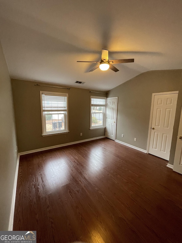 unfurnished room featuring lofted ceiling, dark wood-type flooring, and ceiling fan